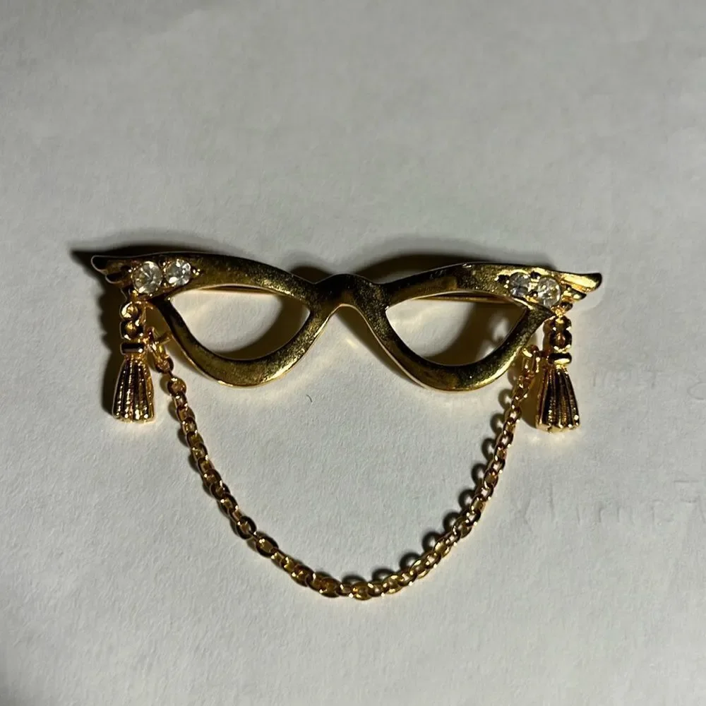 Avon golden eyeglass holder brooch with gold tassel.